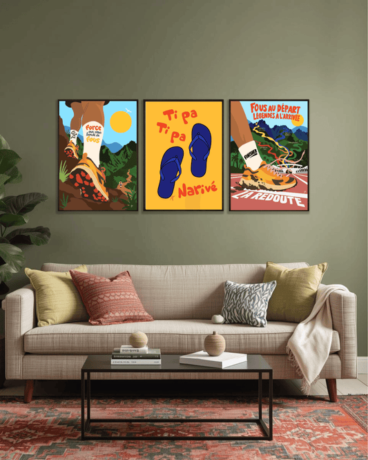 Composition murale de trois affiches colorées du Grand Raid de La Réunion, illustrées par Lefilariane et présentées dans des cadres noirs au-dessus d'un canapé dans un salon.